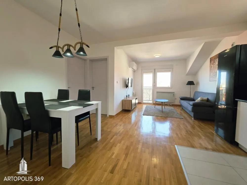 Living room with a dining area and parquet flooring.