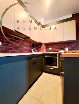 Modern kitchen with dark cabinets and brick wall details. - image 3