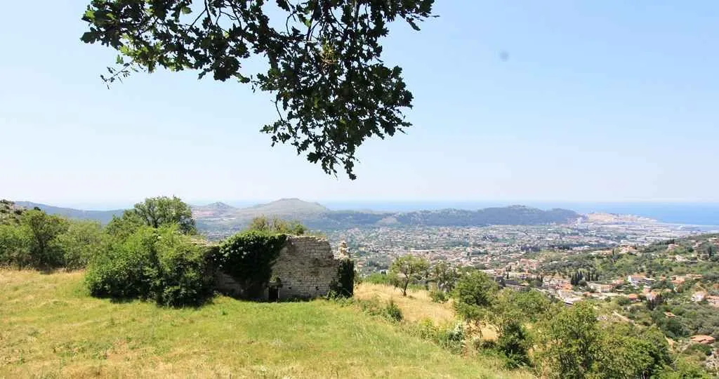 Pogled sa imanja na grad i more sa starom kamenom ruševinom.