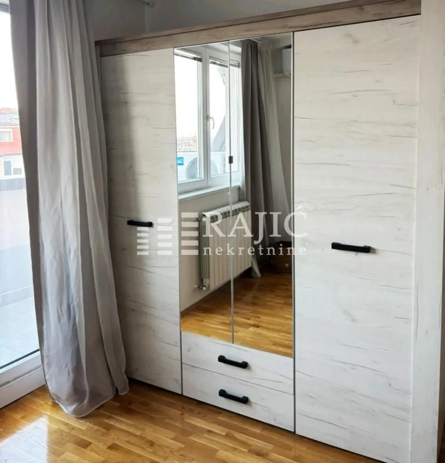 Bedroom with a large wardrobe and wooden flooring.