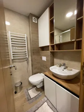 Moderno opremljeno kupatilo sa umivaonikom, WC šoljom i zidnim ormarićem sa ogledalom. - image 6