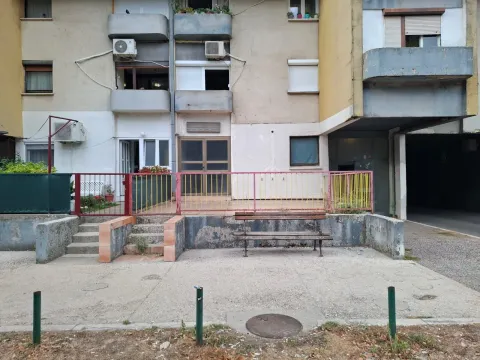 Pogled na spoljašnjost stambene zgrade sa klupom i prilazom. - image 2