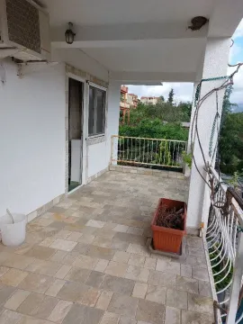 Natkrivena terasa sa popločanim podom i pogledom na zelenilo. - image 6