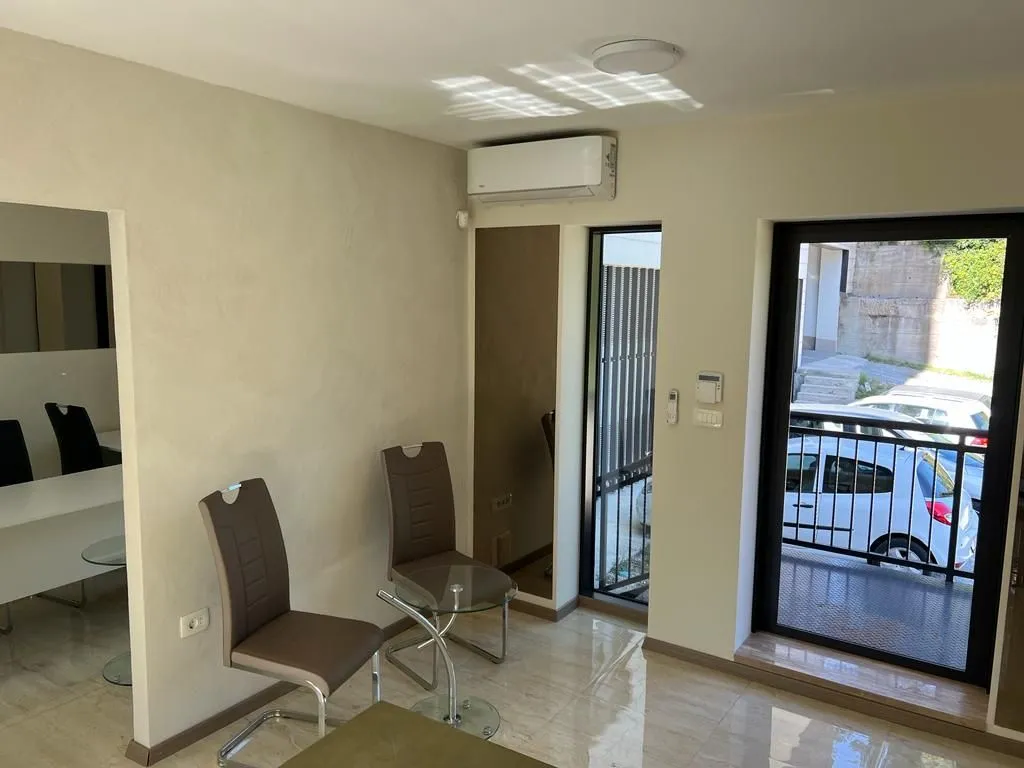 Living room with chairs, a small table, and an air conditioning unit.