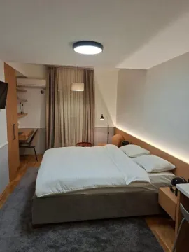 Modern bedroom with a double bed, desk, and wardrobe. - image 4