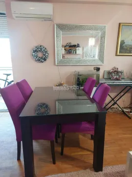 Dining area with a glass table and purple chairs. - image 15