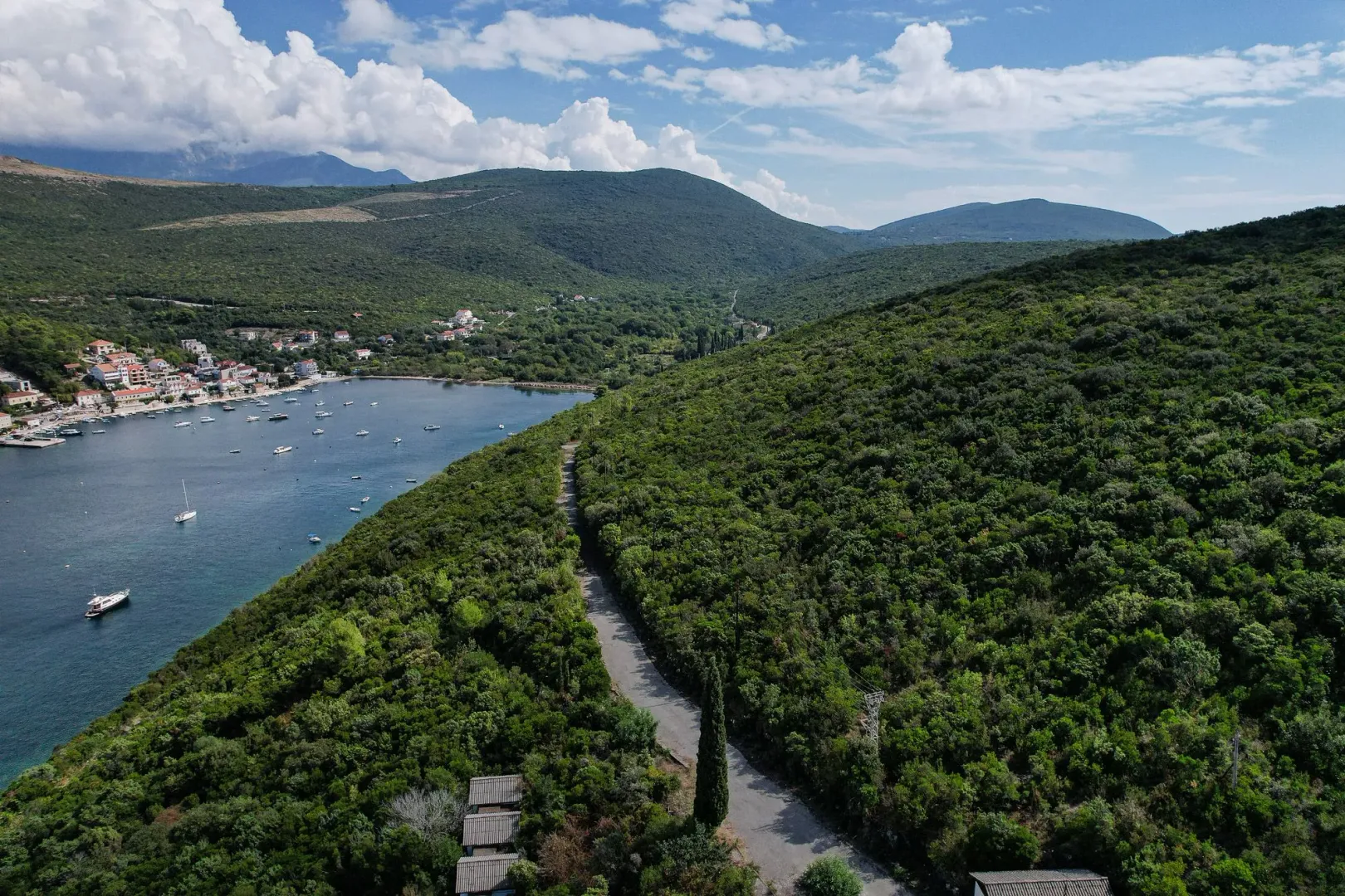 Pogled iz vazduha na uvalu, brda i šumski pejzaž.