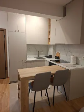 Modern kitchen with a dining table and chairs. - image 8