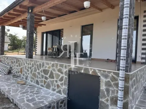 Covered stone-clad terrace of the house with columns and a yard view. - image 13