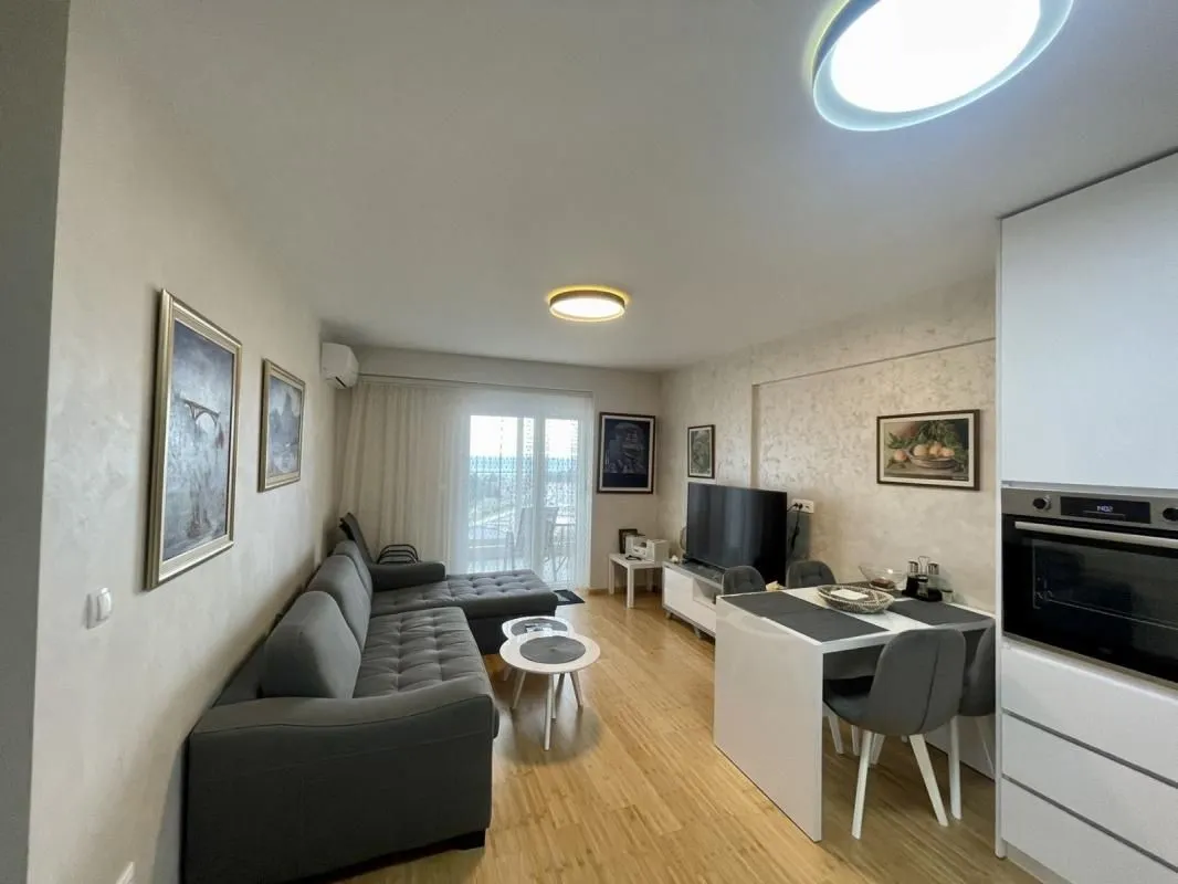 Living room with a sofa, dining table, and kitchen units in the extension.