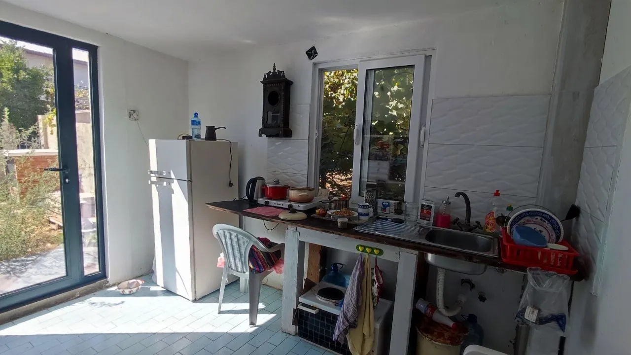 Manja kuhinja sa osnovnim elementima, frižiderom i sudoperom.