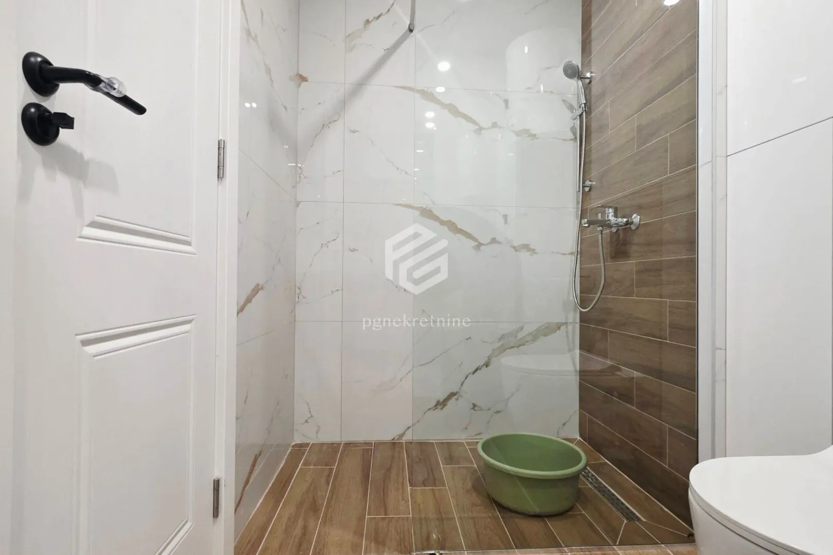 Modern bathroom with a shower cabin and ceramic tiles.