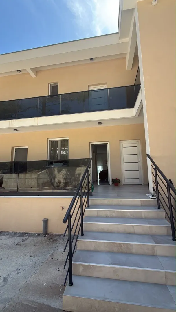 Exterior of a two-story house with stairs and terraces.