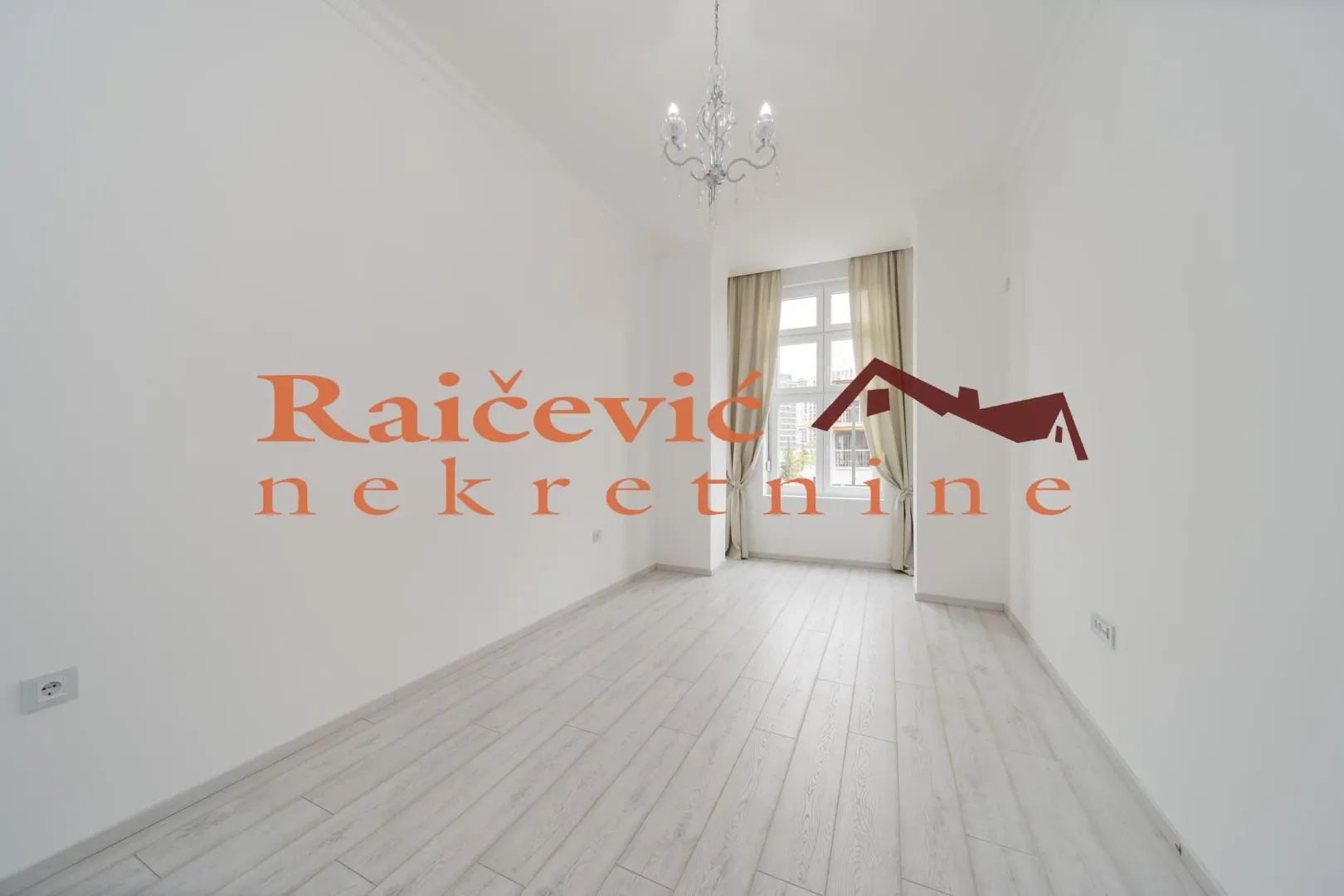 Empty bright room with white walls and wooden flooring.