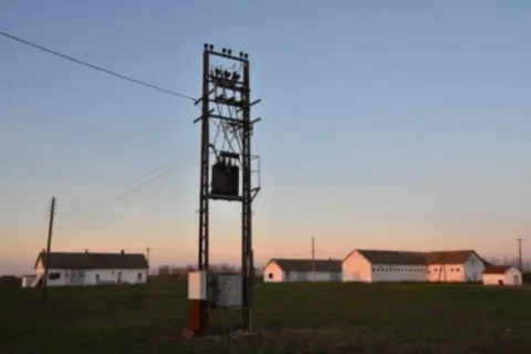 Pogled na eksterijer seoskog imanja sa poljskim objektima i stubom električne mreže. - image 5