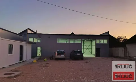 Exterior view of the commercial building with a yard and parked vehicles. - image 4