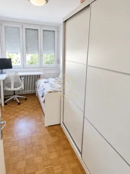 Dečja soba sa krevetom, velikim ormanom i radnim stolom pored prozora. - image 3