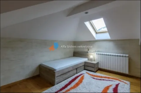 Attic bedroom with a bed and a roof window. - image 15
