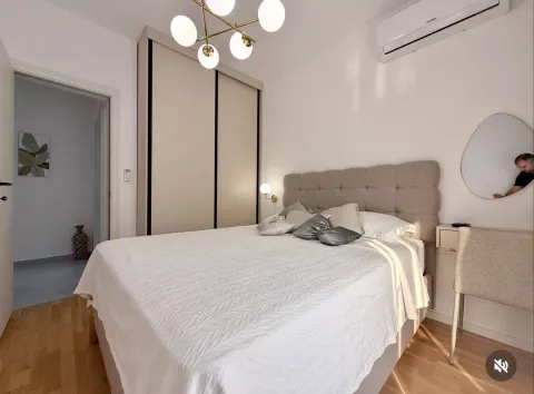 Bright and tidy bedroom with a double bed, wardrobe, and modern chandelier. - image 6