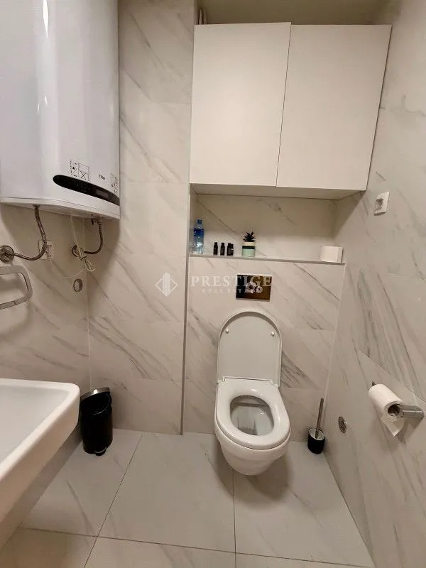 Moderne kupatilo sa bijelim pločicama i ugradnim elementima.