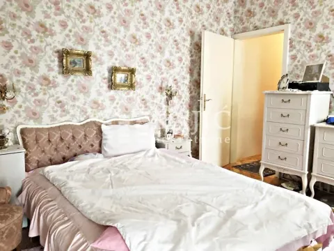 Bedroom with a bed, dresser, and patterned wallpaper. - image 10