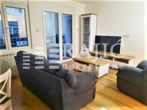 Spacious living room furnished with seating, a television, and hardwood floors. - image 3