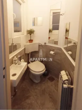 Manje kupatilo sa toaletom, umivaonikom i ogledalima na zidu. - image 11
