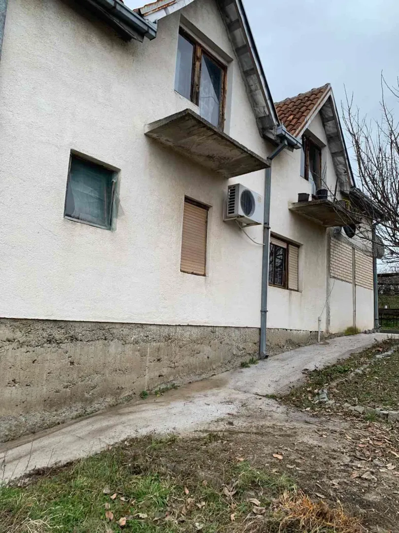 Pogled na spoljašnjost kuće sa fasadom i prozorima.