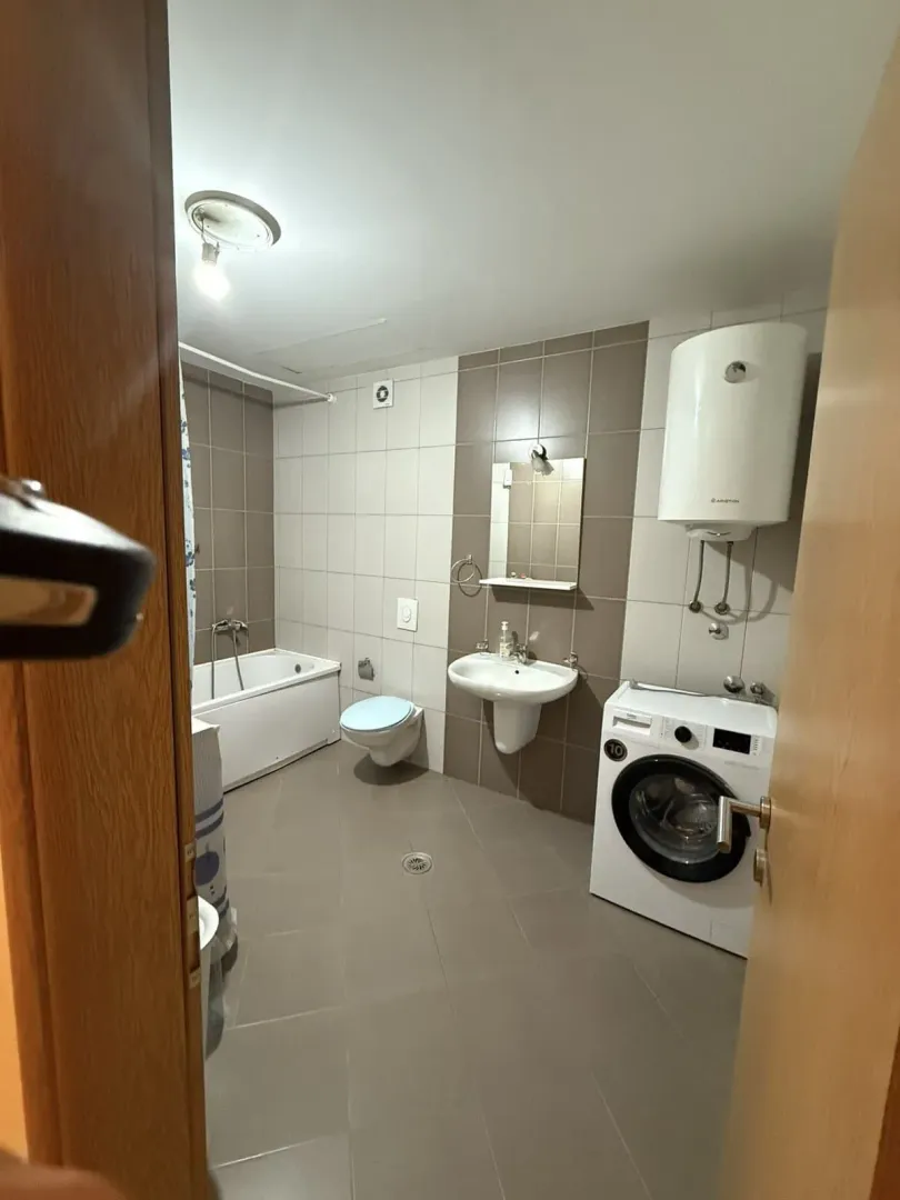 Bathroom equipped with a bathtub, washbasin, toilet, water heater and washing machine.