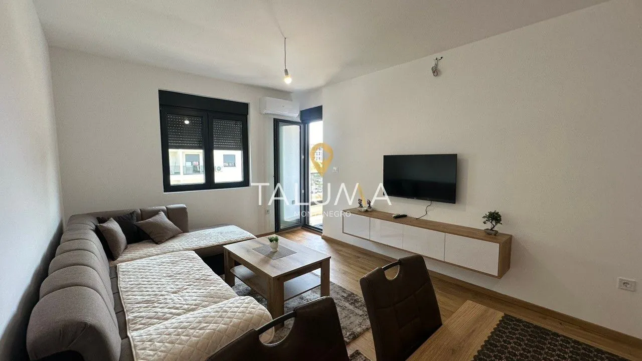 Living room with a sofa, TV, and access to the terrace.