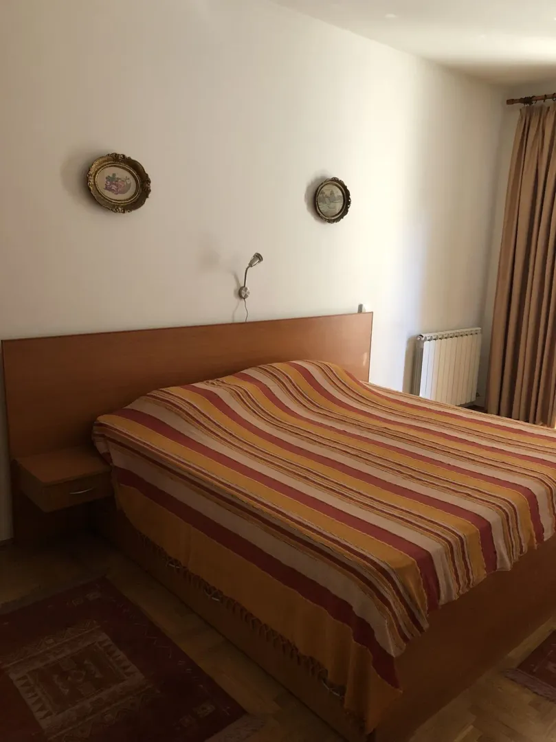 A bedroom featuring a large double bed with a wooden headboard.
