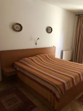 A bedroom featuring a large double bed with a wooden headboard. - image 10