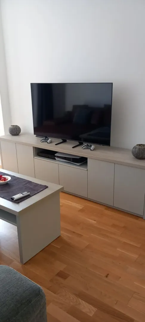 Bright living room featuring a modern TV console and a coffee table.