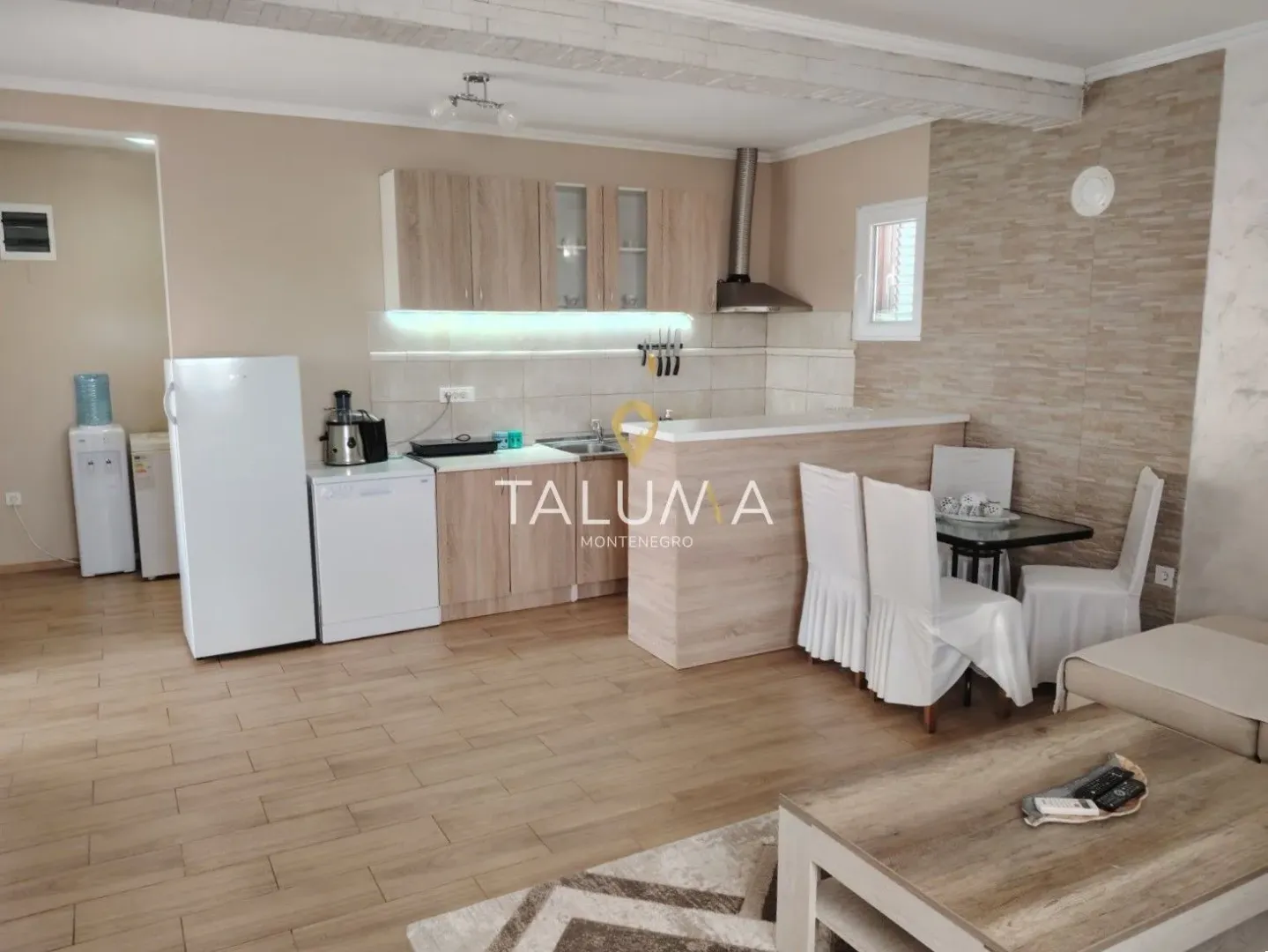 Open-plan kitchen with a breakfast bar and dining table integrated into the living area.