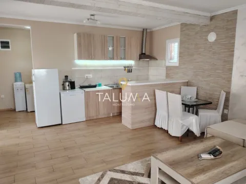 Open-plan kitchen with a breakfast bar and dining table integrated into the living area. - image 4