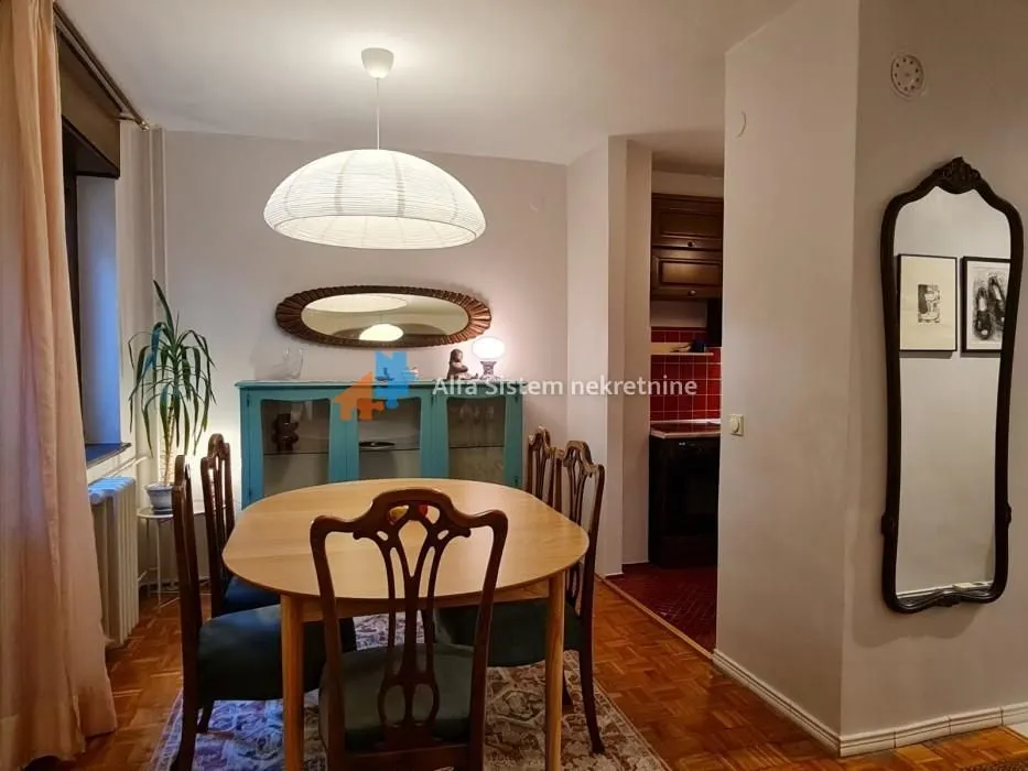 Dining area with a wooden table and chairs, connected to the kitchen.