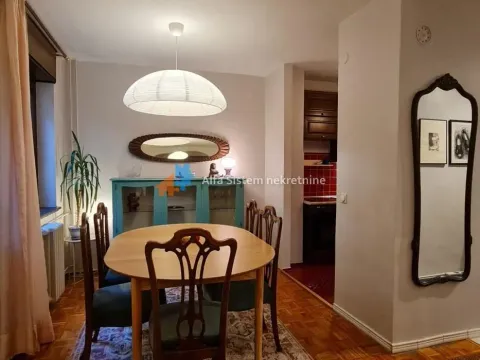 Dining area with a wooden table and chairs, connected to the kitchen. - image 7