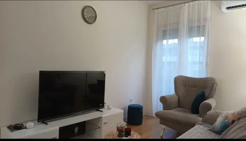 Dnevna soba sa garniturom, televizorom i izlazom na terasu. - image 2