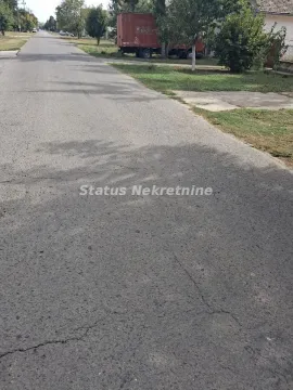 Asphalt road in front of the house with a green area and a parked truck in the background. - image 6