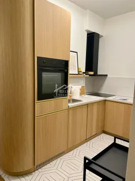 Modern kitchen with wooden cabinetry and built-in appliances. - image 4