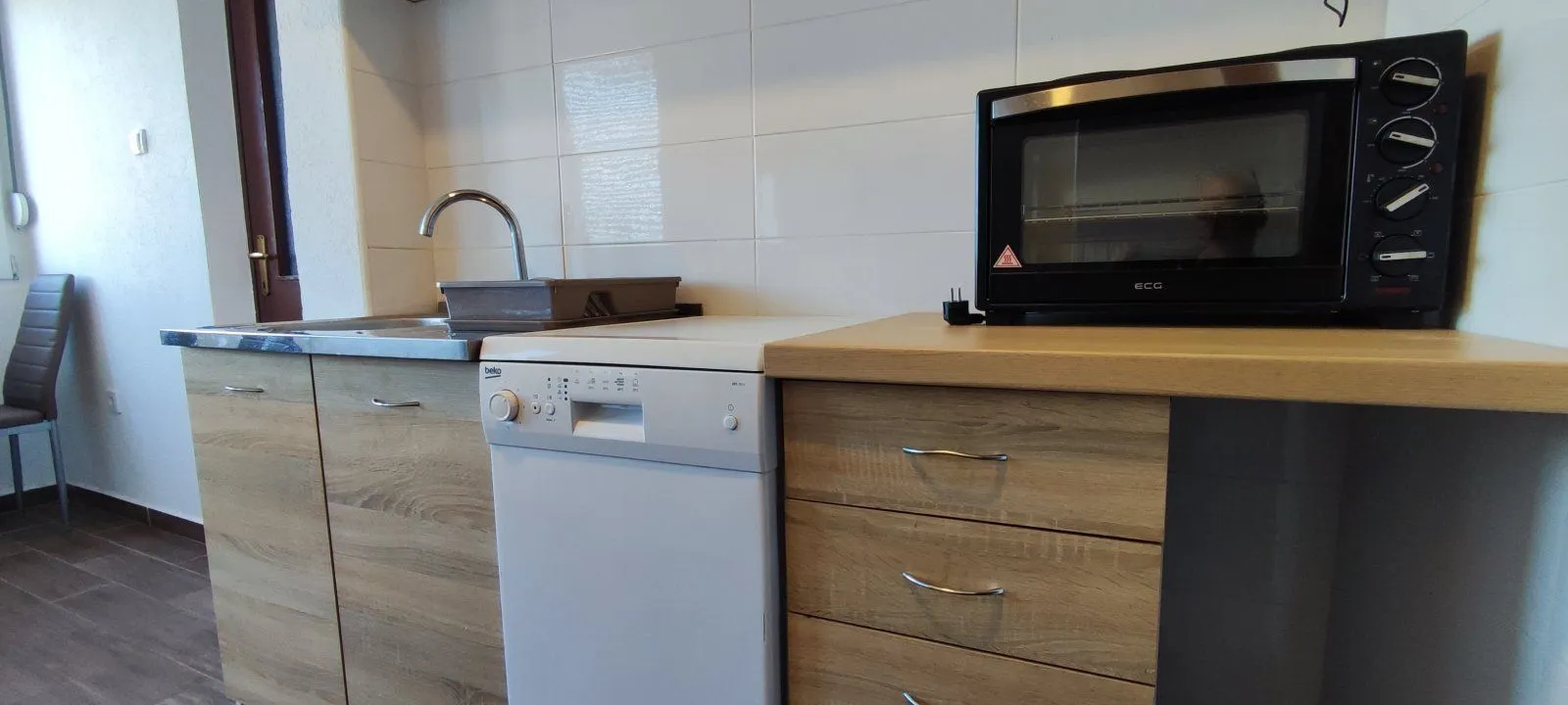 Part of the kitchen with cabinets, a dishwasher, and a mini oven.