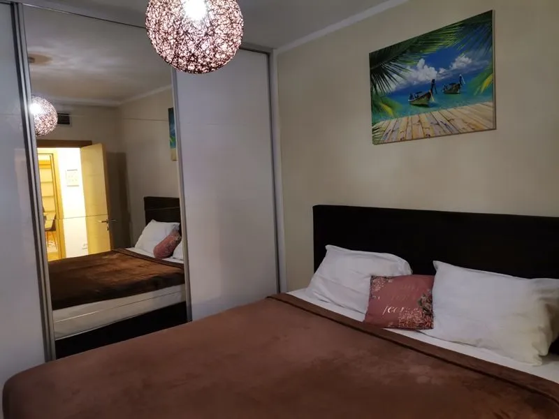 Bedroom with a double bed, large mirrored wardrobe, and wall art.