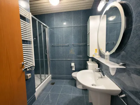 Blue-tiled bathroom featuring a shower cabin, washbasin, and mirror. - image 13