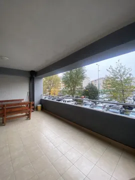 A spacious tiled terrace with a wooden bench and a view of the surroundings. - image 4