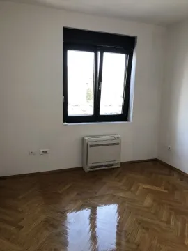 Empty room with polished parquet flooring, a window, and a wall-mounted AC unit. - image 16