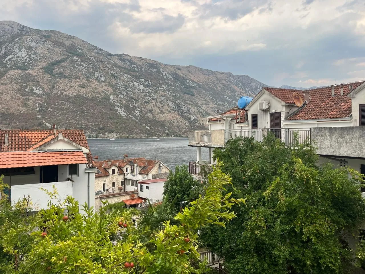 Pogled sa terase na more i okolne planine u primorskom naselju.