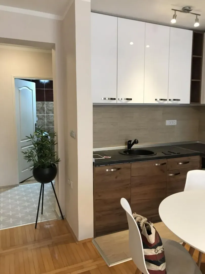Kitchen with wooden and white cabinetry and a dining table.