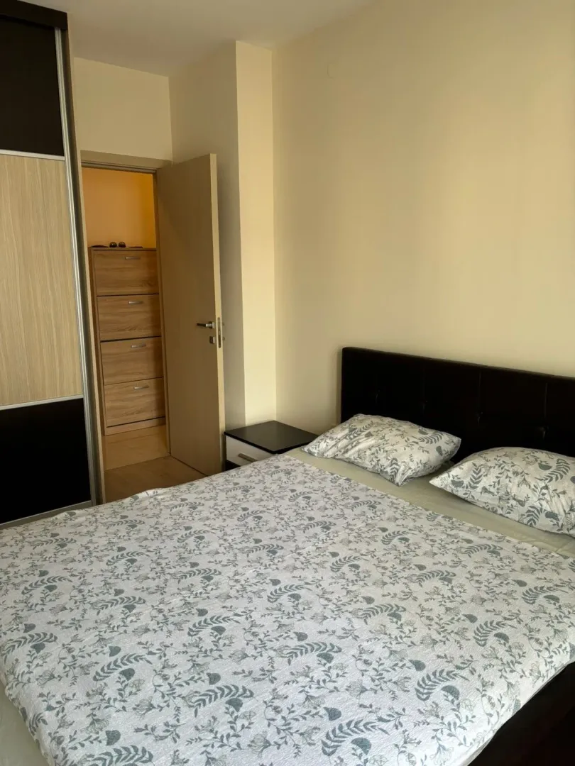 Furnished bedroom with a double bed, wardrobe, and an open door leading to a storage room.