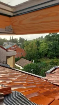 Pogled na krovove i zeleno okruženje sa prozora potkrovlja. - image 5