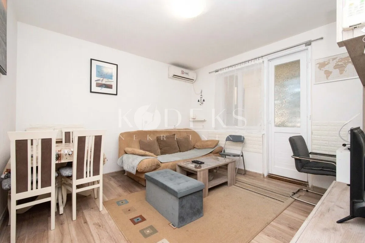 Living room with sofa, dining table and access to the terrace.
